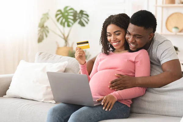 Happy expectant africký americký pár nakupování on-line, pomocí notebooku — Stock fotografie