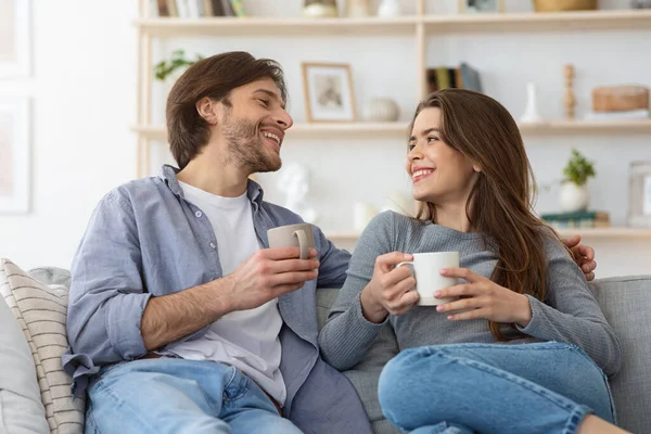 Veselý pár vede rozhovor a pije kávu doma — Stock fotografie