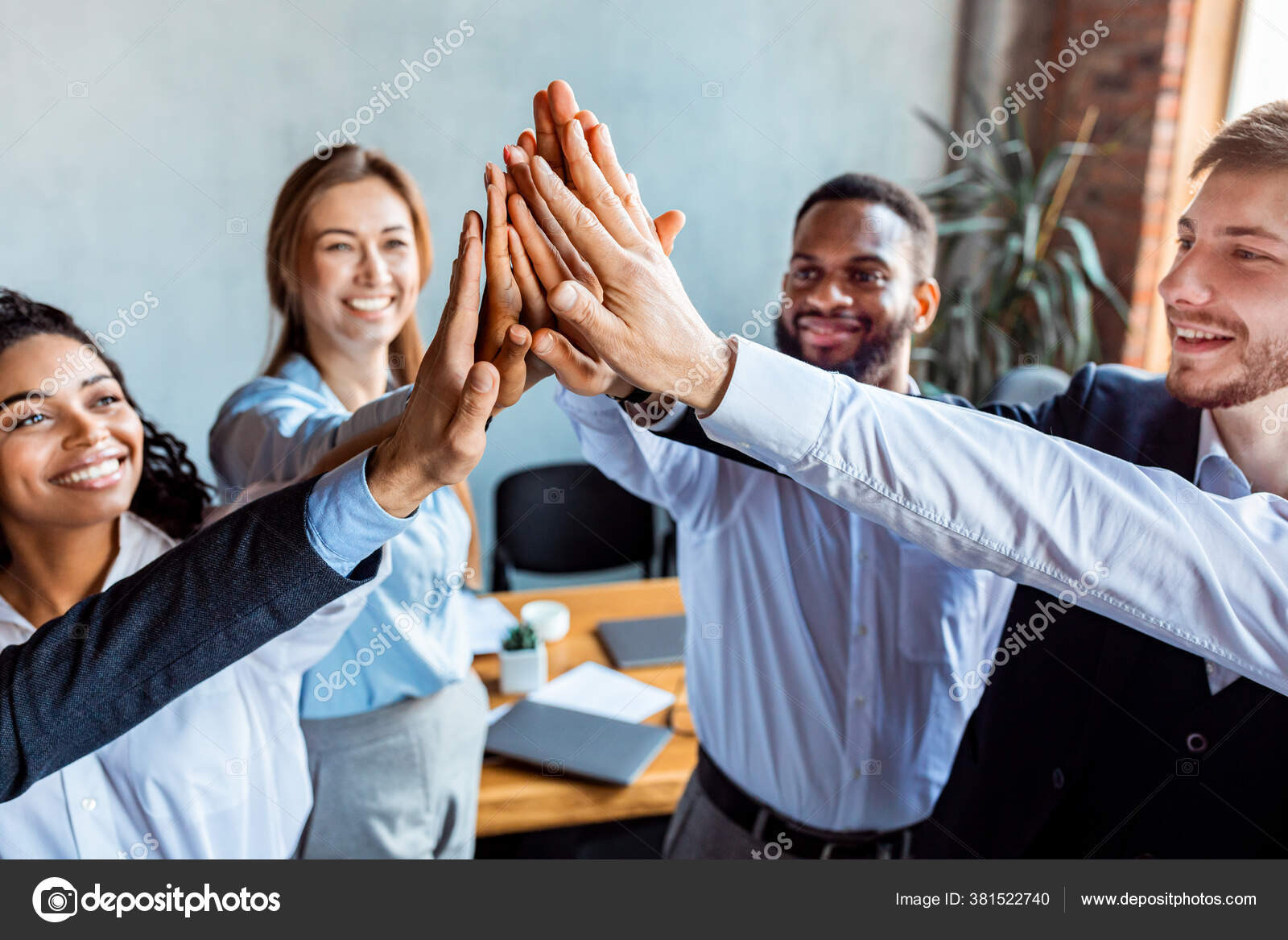 Colleagues Giving High-Five Celebrating Business Success Standing In Office  Stock Photo by ©Milkos 381522740