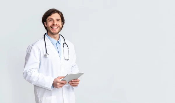 Médico alegre segurando tablet digital nas mãos — Fotografia de Stock