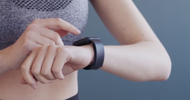 Молодая женщина с помощью фитнес-умных часов с сенсорным экраном — стоковое видео