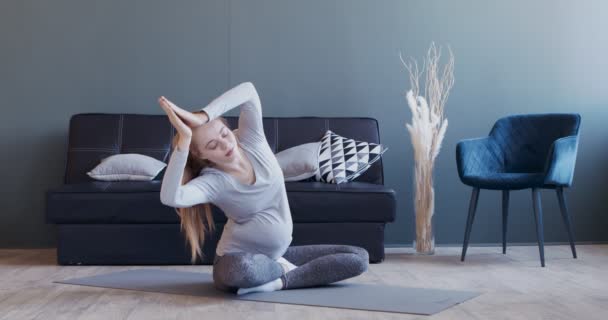 Junge schwangere Mädchen praktizieren pränatales Yoga zu Hause — Stockvideo