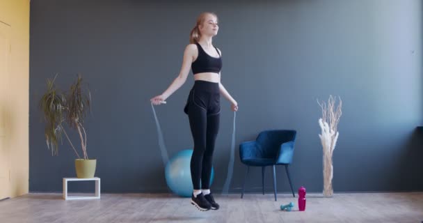 Joven mujer deportiva haciendo ejercicio con la cuerda saltando — Vídeo de stock