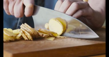 Evde çay içmek için taze zencefil dilimleyen kadın elleri.