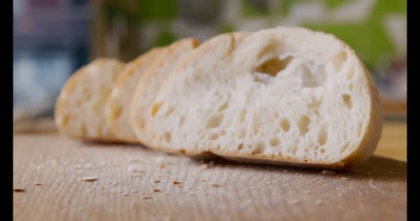 Свежеиспеченный нарезанный хлеб на деревенском кухонном столе, закрыть — стоковое видео