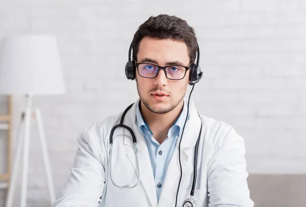 Vraag aan dokter online. Dokter in bril en koptelefoon beantwoordt vragen van volgers — Stockfoto