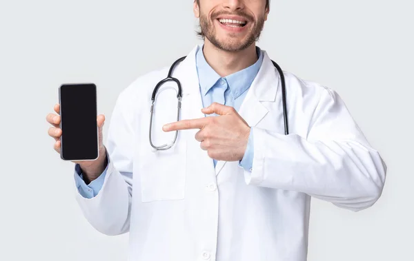 Médico profissional mostrando telefone inteligente em branco — Fotografia de Stock
