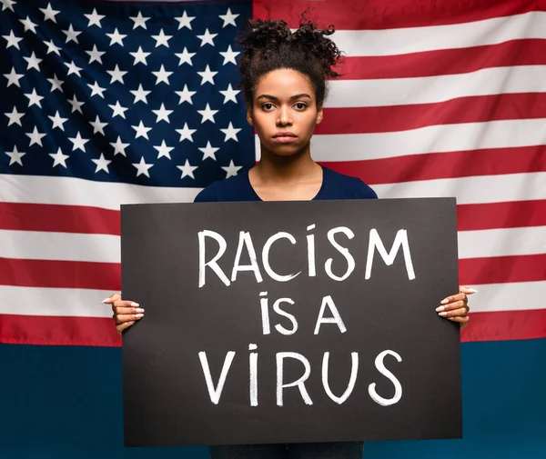 Африканская американка с плакатом забастовки на фоне американского флага — стоковое фото