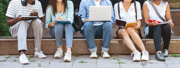 Gruppo di studenti universitari che studiano all'aperto con laptop e cartelle di lavoro, raccolto — Foto Stock