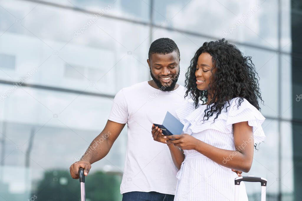 New Destinations. Happy african couple checking passports and tickets before departure