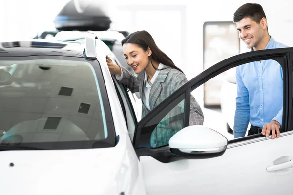 Schöne glückliche Familie wählt Auto suchen im Salon — Stockfoto