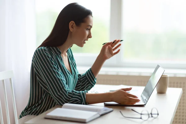 Empresária no laptop fazendo chamada de vídeo sentado no escritório moderno — Fotografia de Stock