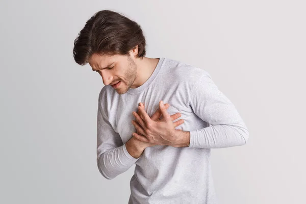 Heart attack at young age. Man presses his hands to chest and facial expression pain — Stock Photo, Image