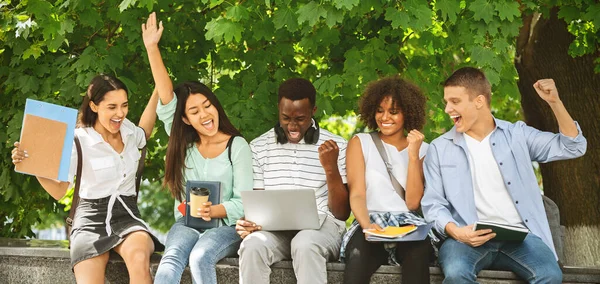 Étudiants acceptés. Joyeuse adolescence multiculturelle célébrant le succès avec ordinateur portable en plein air — Photo