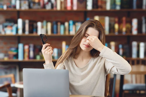 Retrato de menina cansada de óculos e um laptop — Fotografia de Stock