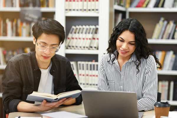 Dos estudiantes multiculturales sonrientes aprendiendo en la biblioteca pública — Foto de Stock