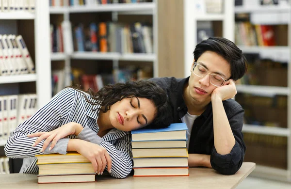 Estudiantes cansados durmiendo en la biblioteca pública — Foto de Stock