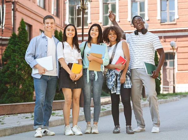 Groep gelukkige studenten poseren buiten na lezing op de universiteit — Stockfoto