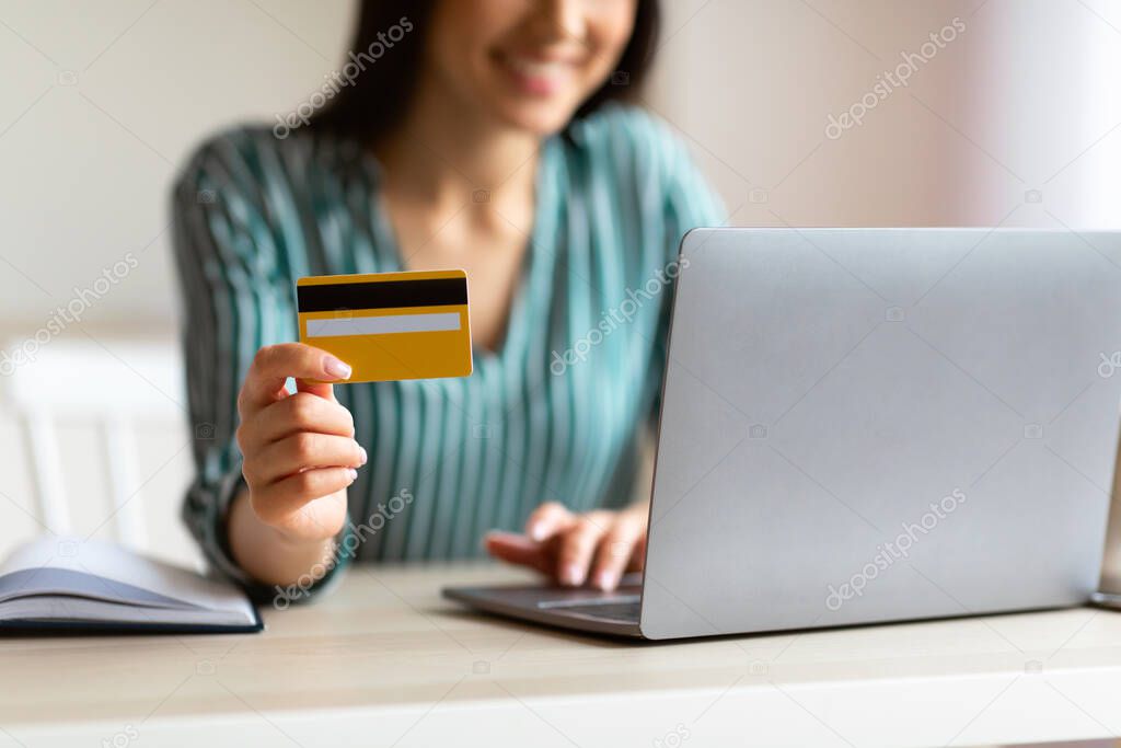 Businesswoman Using Laptop And Credit Card In Office, Cropped