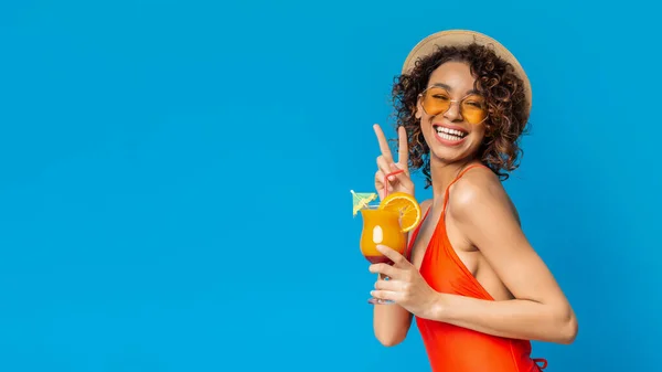 Zomer afro meisje in badpak drinken fruit cocktail en tonen vrede gebaar — Stockfoto