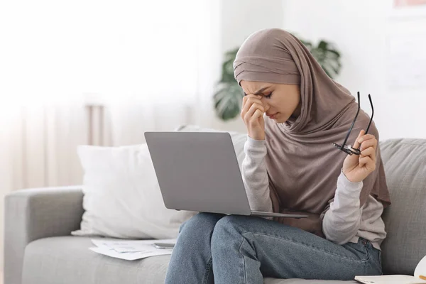 Уставшие глаза. Измученная арабская женщина, измученная после работы над ноутбуком дома — стоковое фото