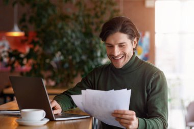 Cafe 'de belgelerle çalışan mutlu girişimci.