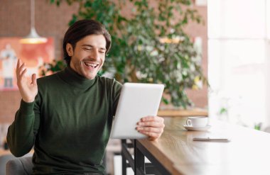 İş adamı, dijital tablet kullanarak ortaklarıyla görüntülü görüşme yapıyor.