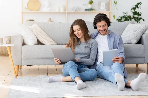 Homme et femme utilisant des gadgets tout en passant le week-end à la maison — Photo