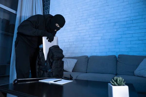 Włamywacz włamuje się do mieszkania lub biura kradnąc komputer — Zdjęcie stockowe