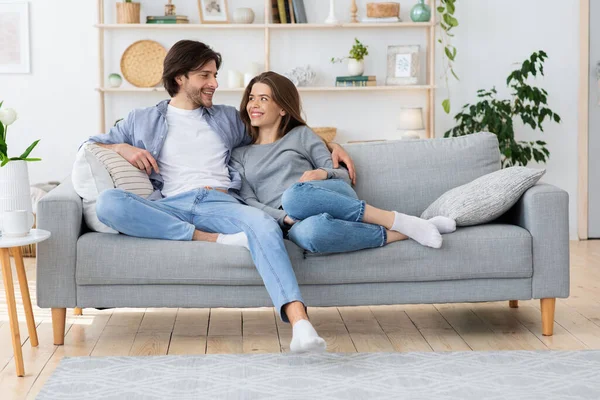 Couple amoureux étreignant sur canapé, se regardant — Photo