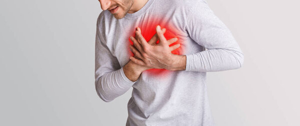 Problems with heart. Man feeling chest pain, presses his hands to highlighted in red place
