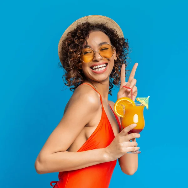 Mayolu neşeli siyah kız yaz kokteylinin tadını çıkarıyor ve barış işareti gösteriyor. — Stok fotoğraf