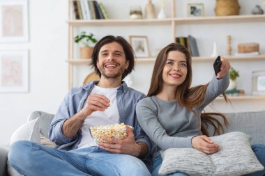 Çiftler hafta sonunu evde televizyon izleyerek geçirirler.