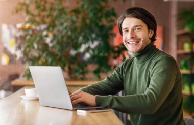 Cafe 'de çalışan neşeli programcı, işinden zevk alıyor.