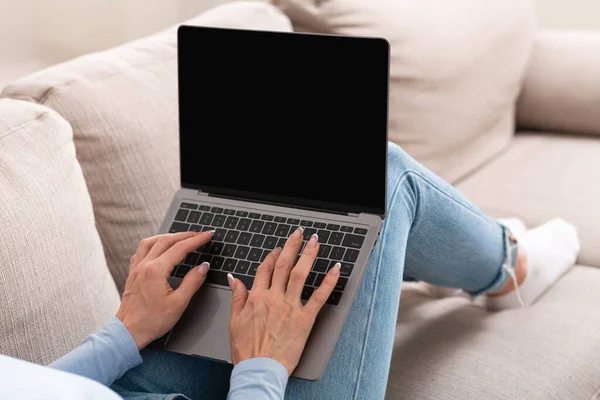 Vorbesc pe canapea cu clientul. Femeie tastând pe laptop-uri cu ecran gol — Fotografie, imagine de stoc