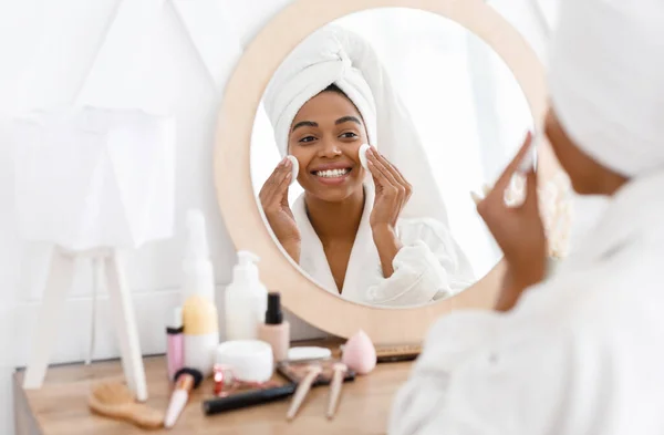 Mulher americana muito africana removendo maquiagem, rosto de limpeza com almofadas de algodão — Fotografia de Stock