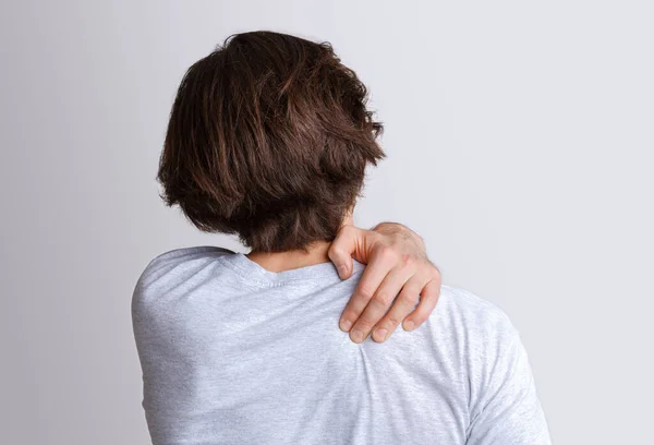 Pain in back and shoulder from working at computer. Man presses his hand to sore spot — Stock Photo, Image