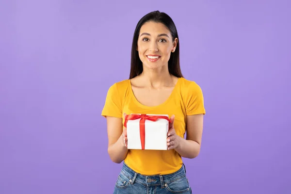 Happy girl holding gift box at studio — Stock fotografie