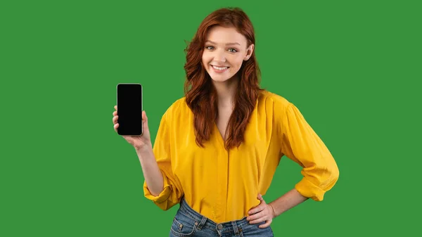 緑の背景に携帯電話の空の画面を示す千年紀の女の子,パノラマ — ストック写真