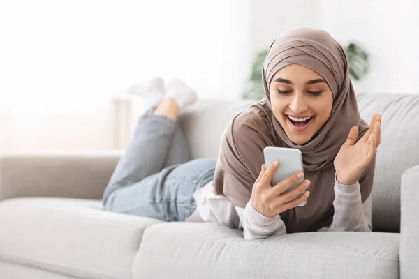 Unerwartete Botschaft. Aufgeregte Araberin hält Smartphone in der Hand und schreit vor Freude — Stockfoto