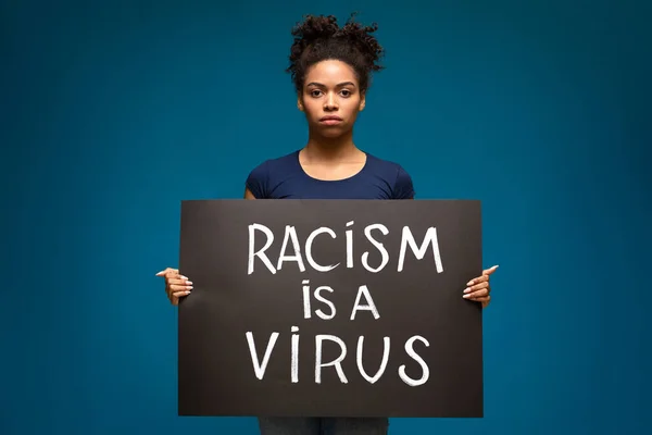 Mulher negra segurando cartaz de demonstração Racismo é um vírus — Fotografia de Stock