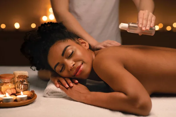 Mulher africana relaxada desfrutando de aromaterapia e massagem no spa — Fotografia de Stock
