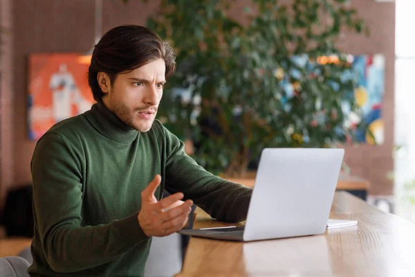 Angry man looking at laptop screen, having troubles with job