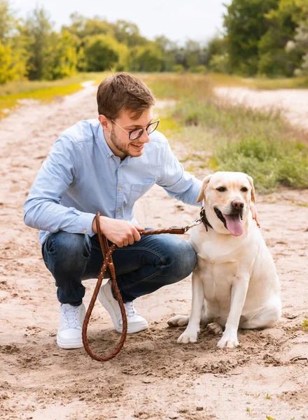 Heyecanlı adam ve Golden Retriever 'ı dışarıda oturuyor. — Stok fotoğraf