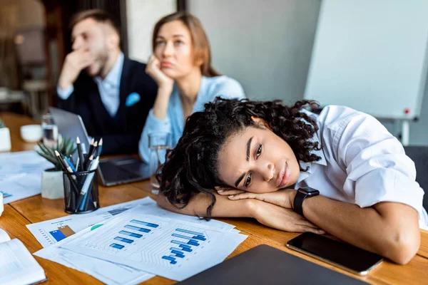 Deprimida señora descansando la cabeza en las manos durante la reunión en el cargo — Foto de Stock