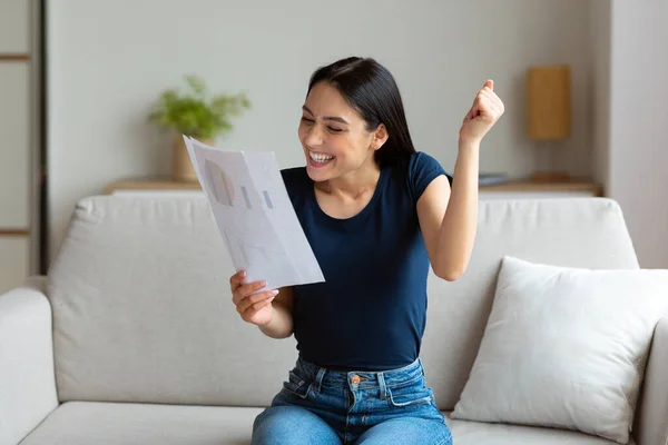 Donna gesticolando sì holding carte seduta su divano a casa — Foto Stock