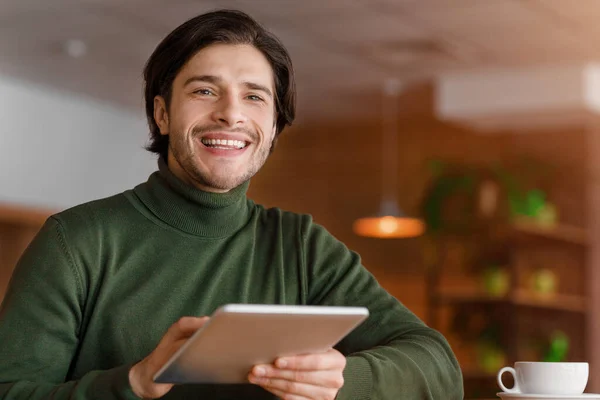 Χαμογελαστός blogger που εργάζεται στο διαδίκτυο στο cafe, χρησιμοποιώντας ψηφιακή ταμπλέτα — Φωτογραφία Αρχείου