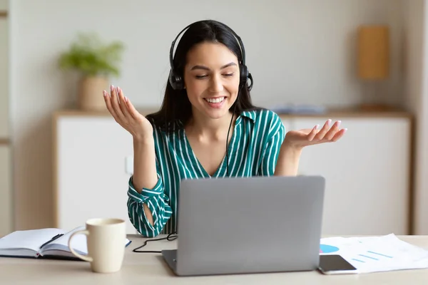 Mujer con auriculares trabajando en servicio de atención al cliente sentada en interiores —  Fotos de Stock