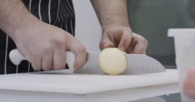 Erkek eller mutfakta soğan doğruyor.