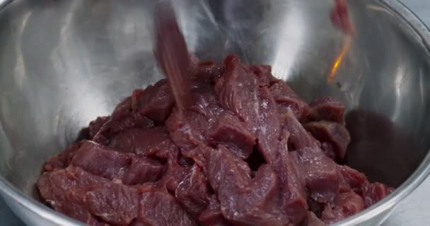 Chef poniendo carne de res cruda en rodajas en un tazón en la cocina — Vídeos de Stock